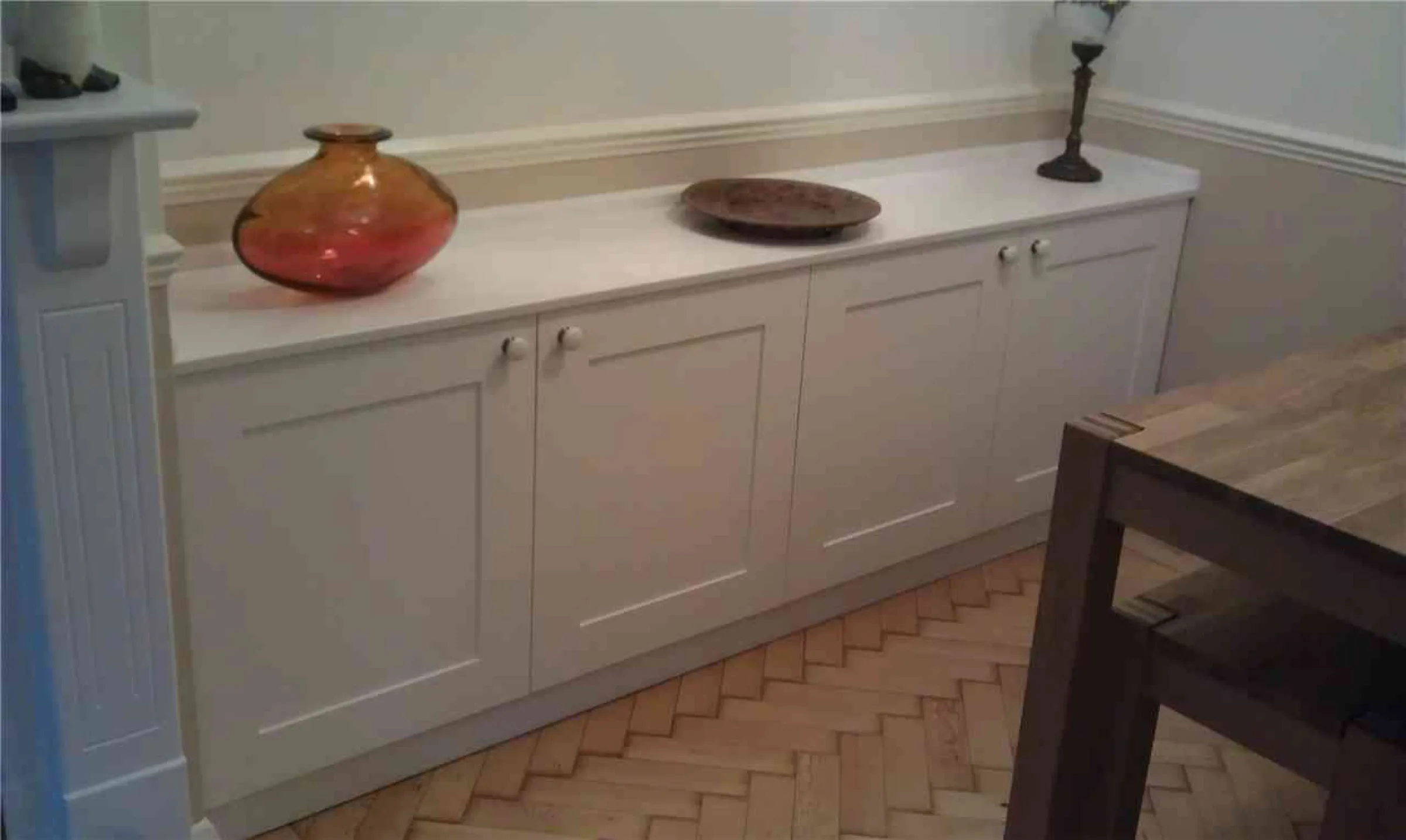 Made-to-measure painted sideboard with Shaker doors in a dining room with herringbone parquet flooring