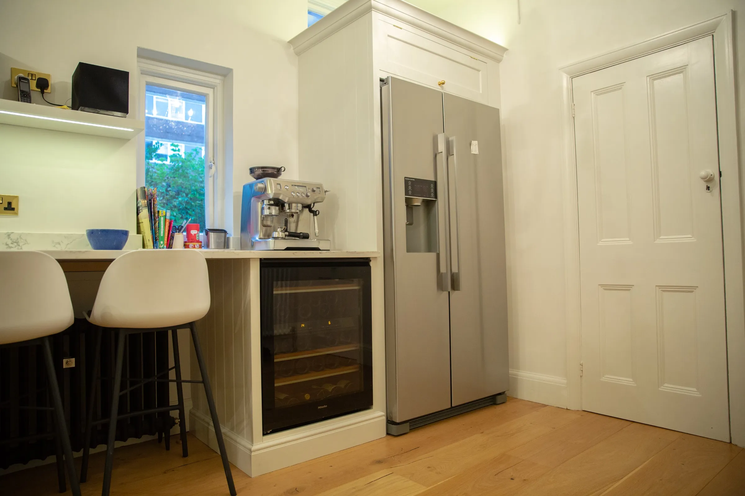 American-style fridge freezer in a bespoke painted housing, beside the under-counter wine cooler and breakfast bar