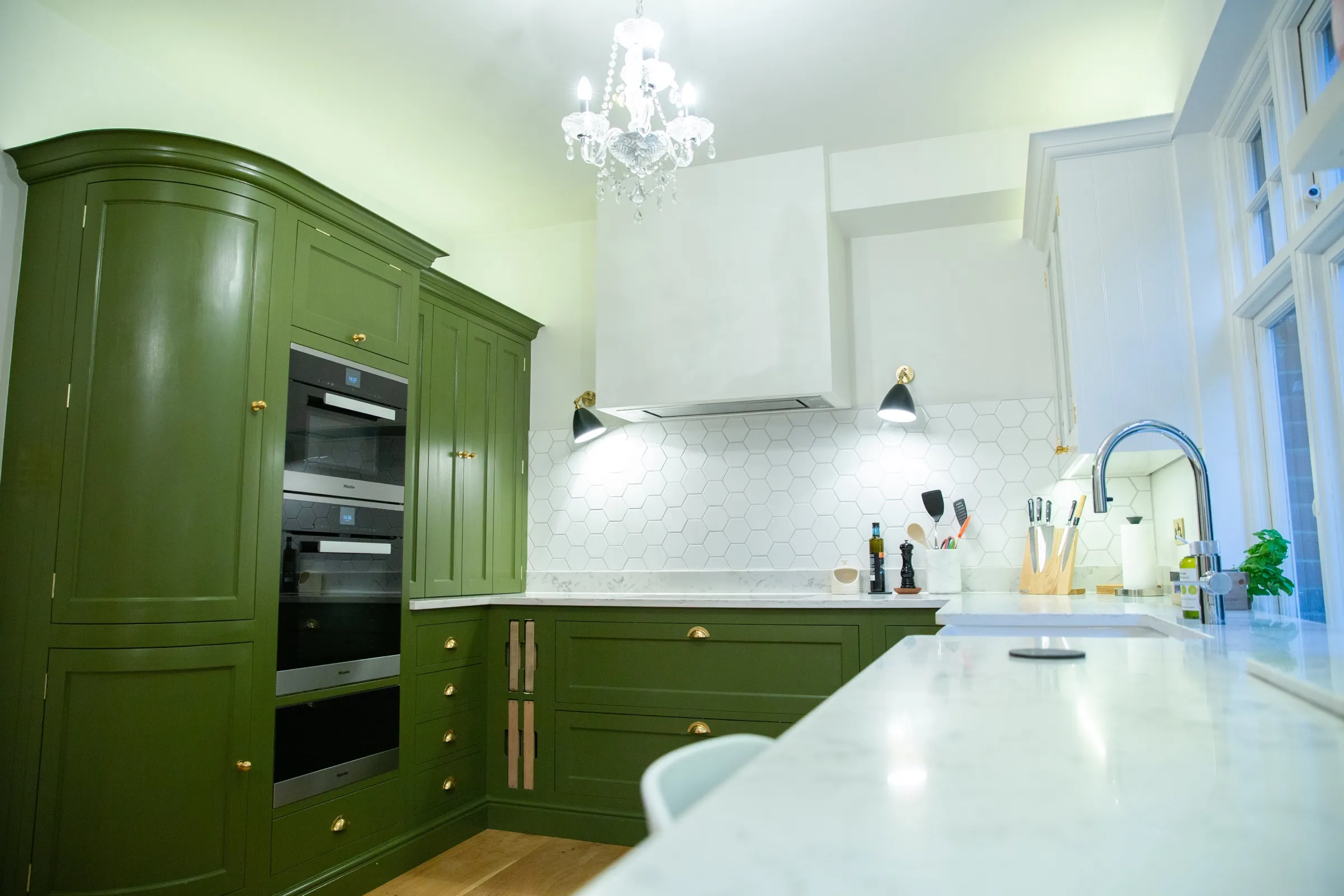 Full-width view of the finished kitchen from the breakfast bar, from the curved larder cabinet to the Belfast sink