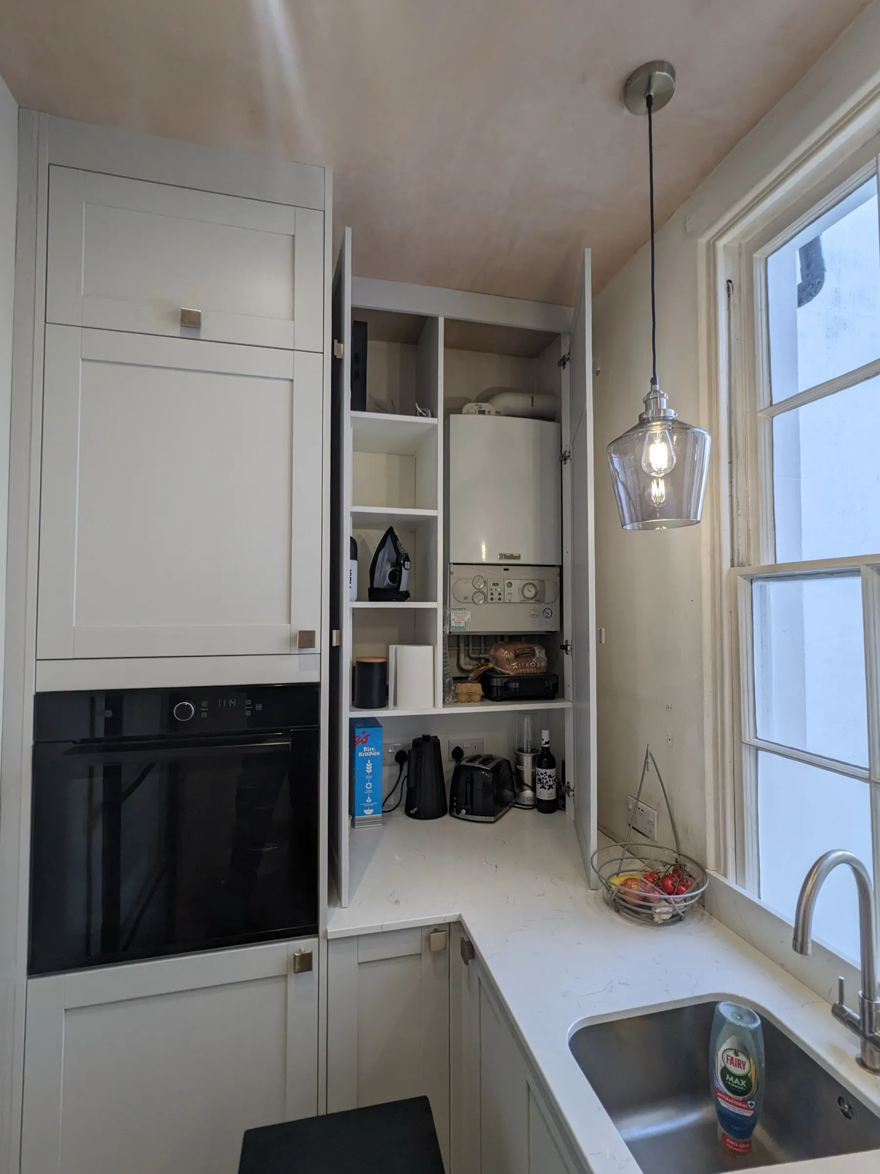 Bespoke tall cupboard with fitted shelving concealing the boiler