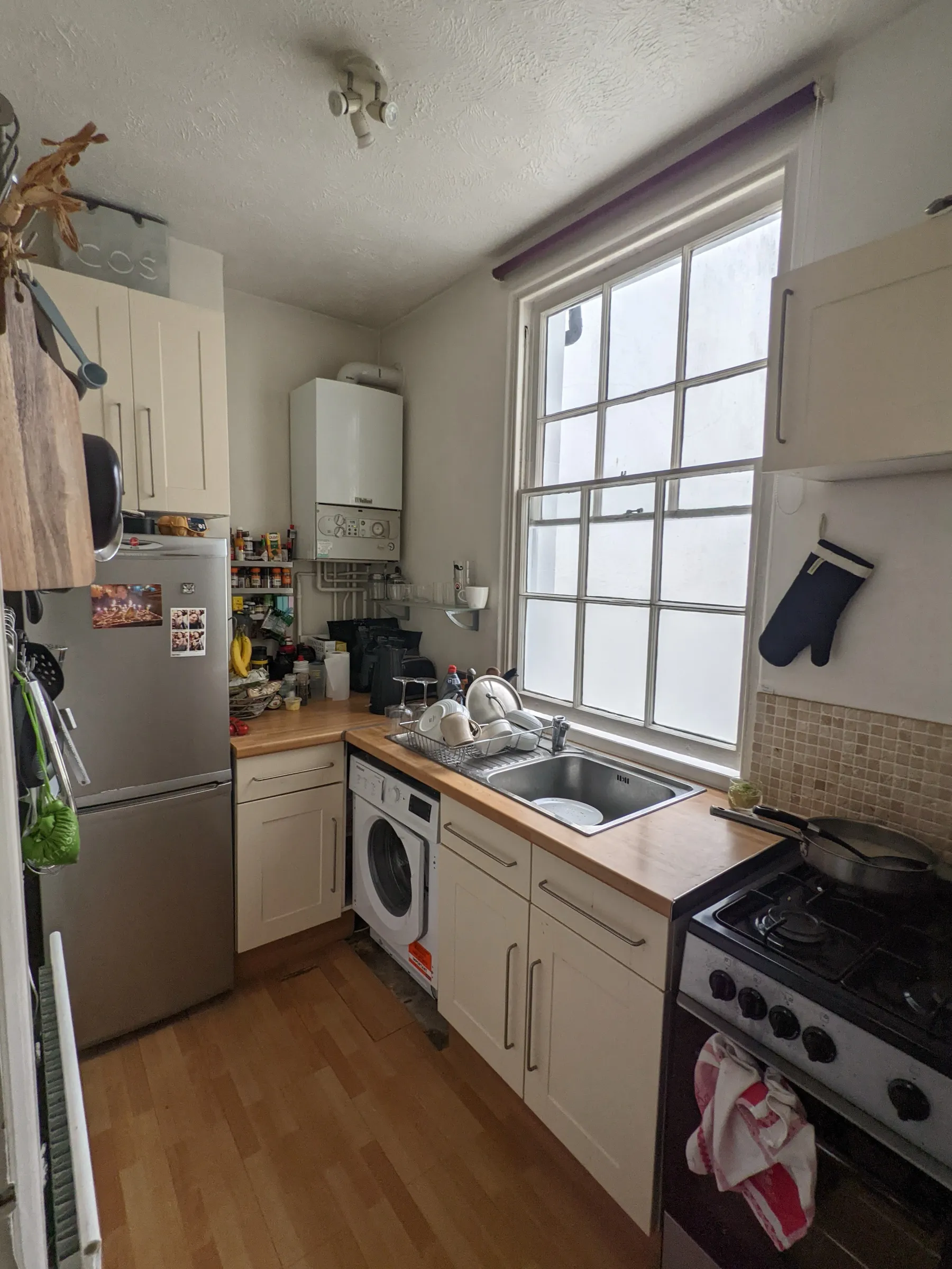 Before the refit: the old cream kitchen and freestanding gas cooker prior to the grey Shaker refit