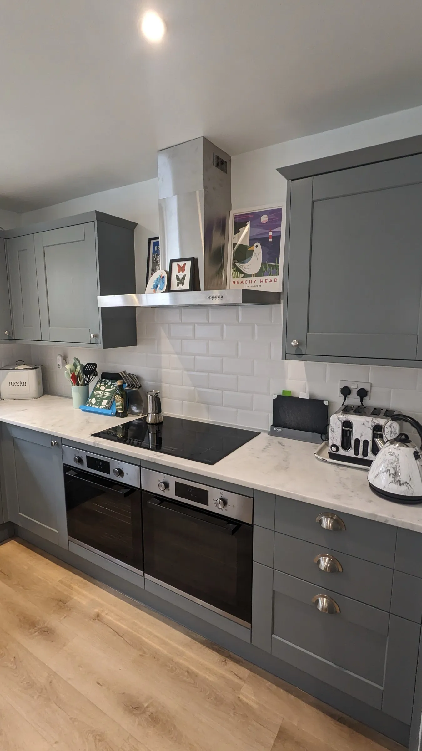 Slate blue Shaker kitchen with bevelled metro tiles, stainless hood and twin ovens