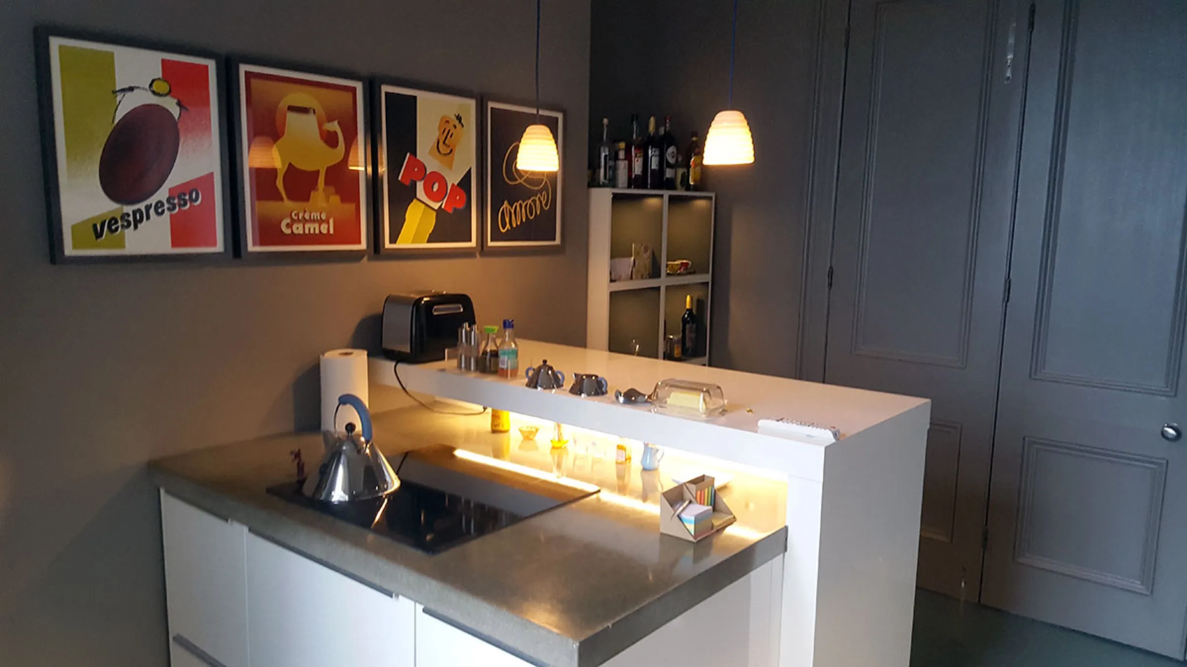 Wide view of the kitchen with concrete-style worktops, raised breakfast bar shelf and grey panelled doors