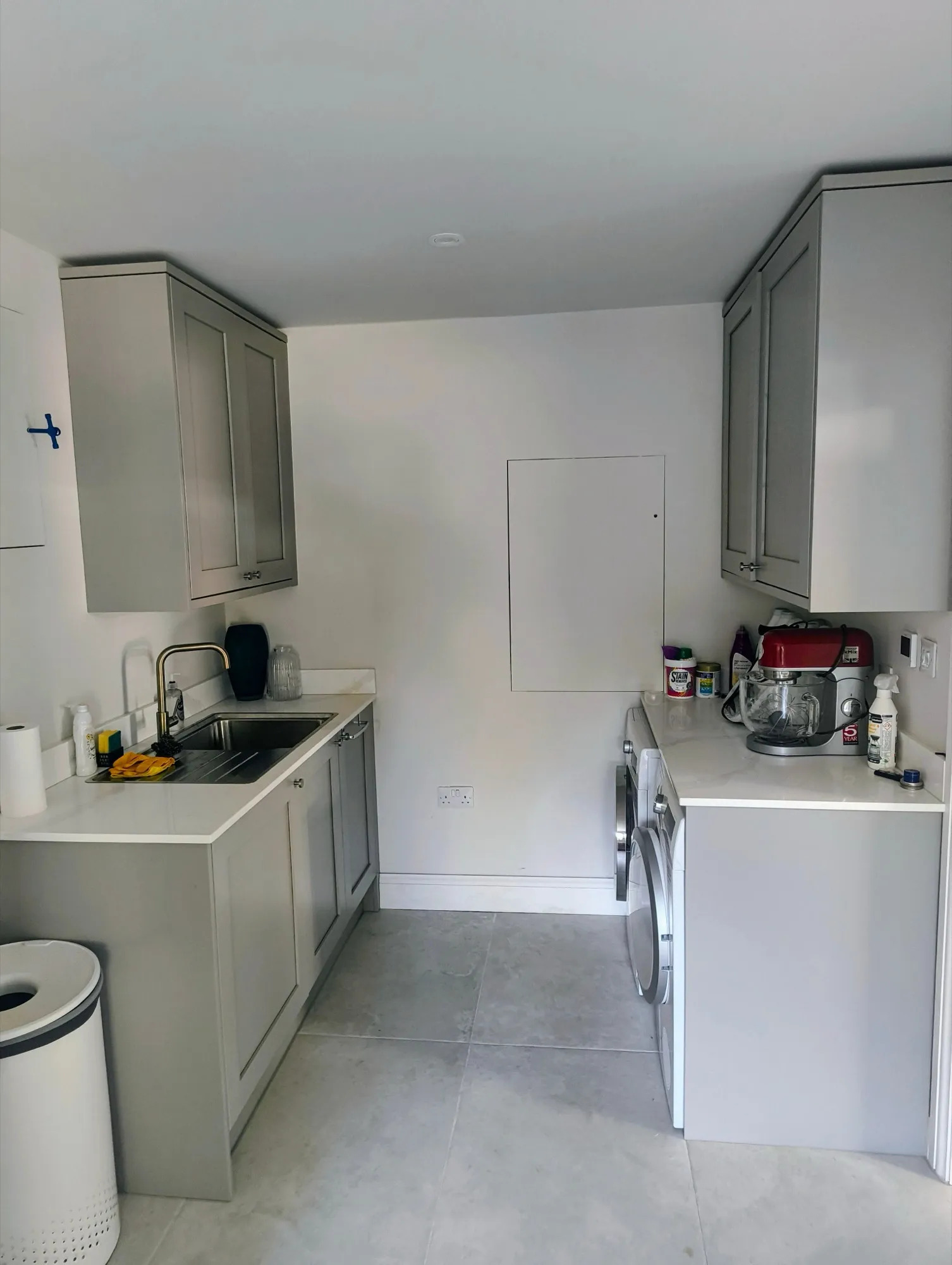 Matching grey utility room with brass tap, quartz worktops and Shaker cabinets