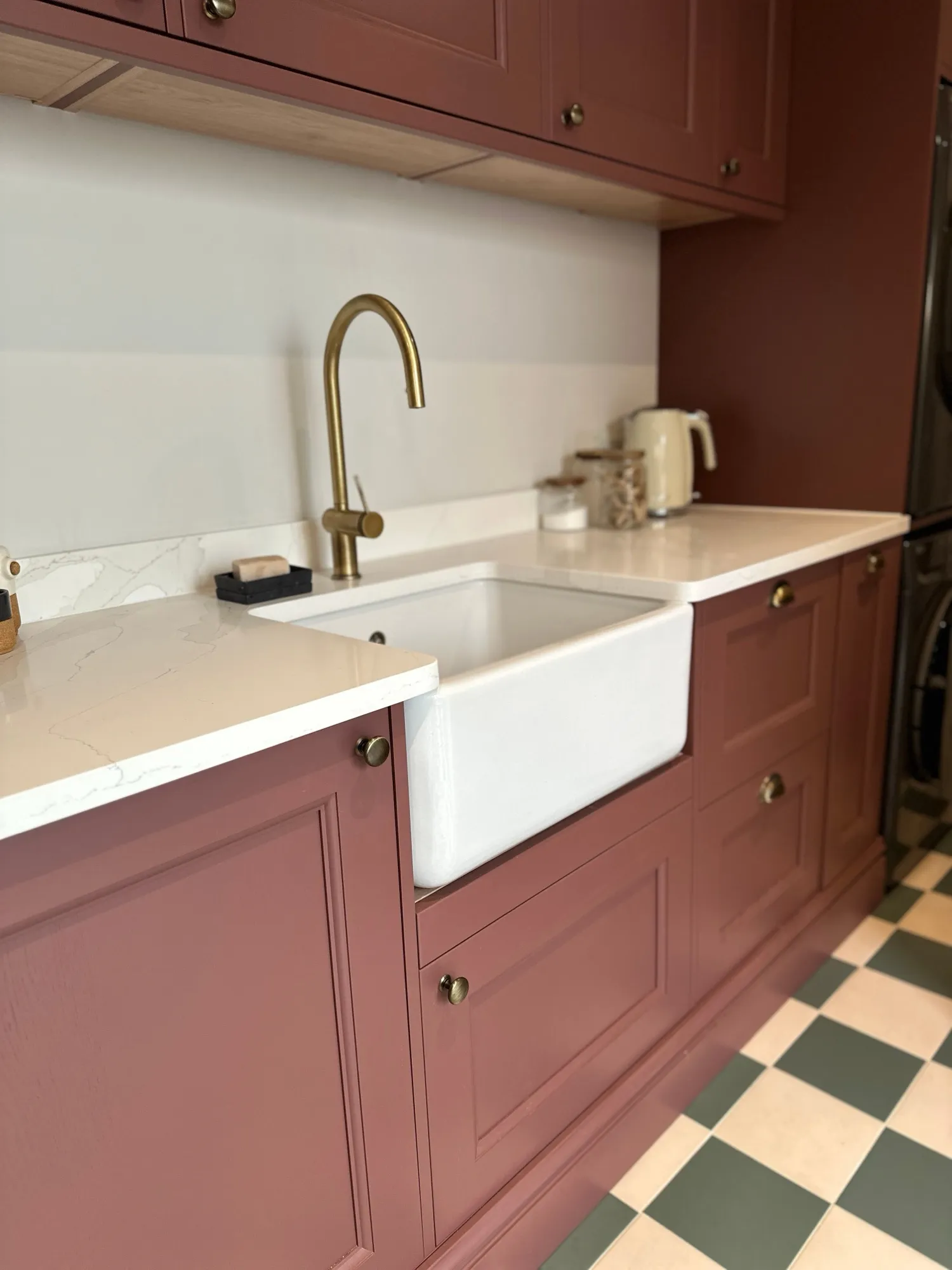 Butler sink with antique brass tap set into a quartz worktop
