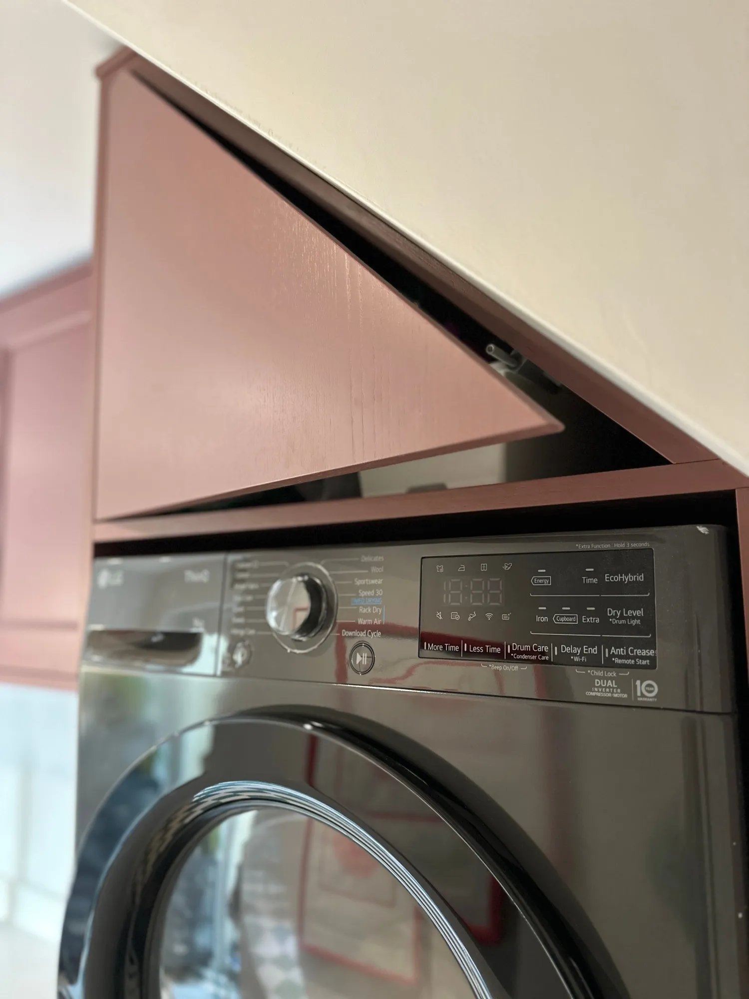 Stacked washing machine and dryer integrated behind bespoke cabinetry